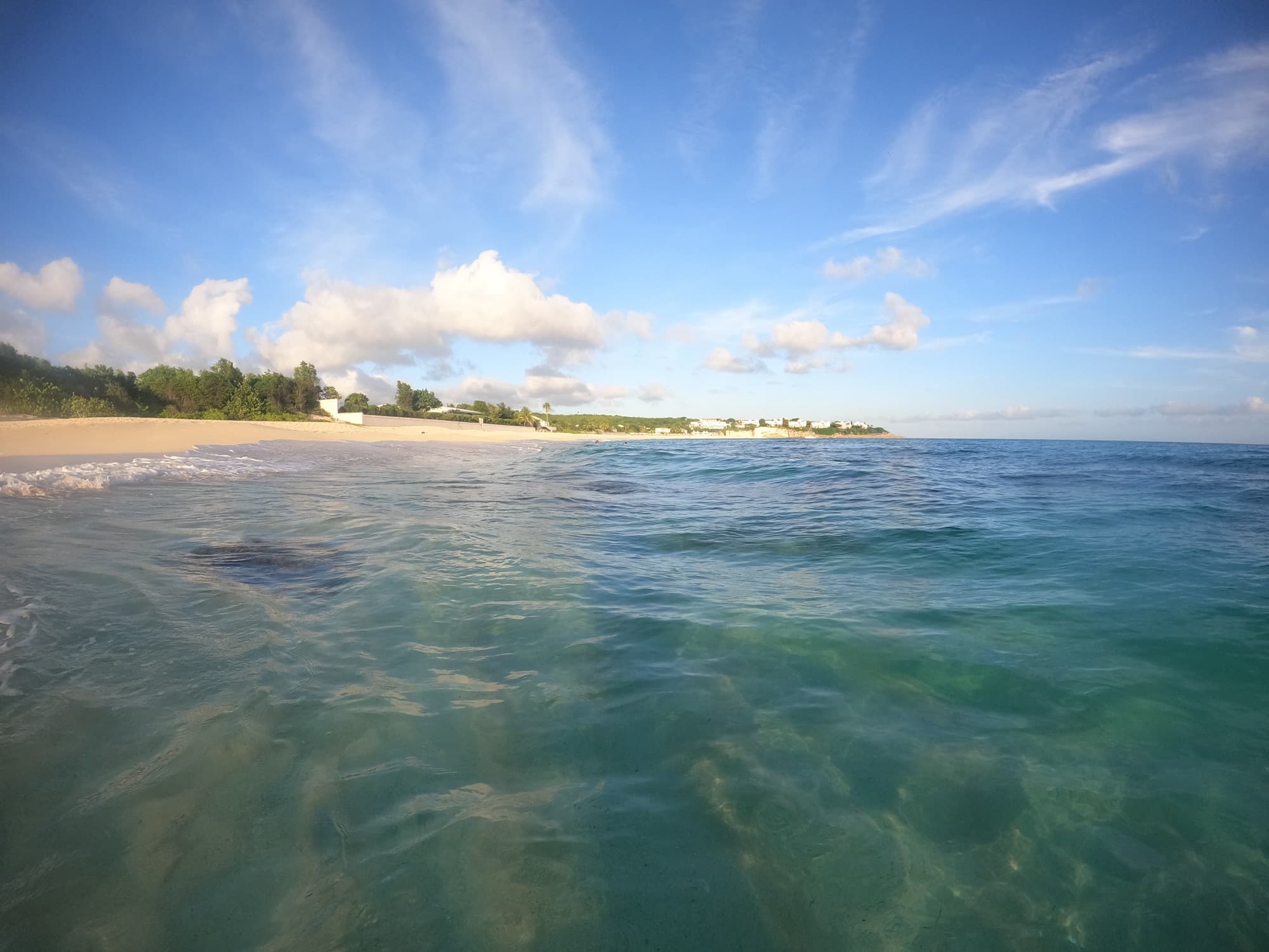 Turquoise water and white sand at Baie Longue beach on a sunny morning
