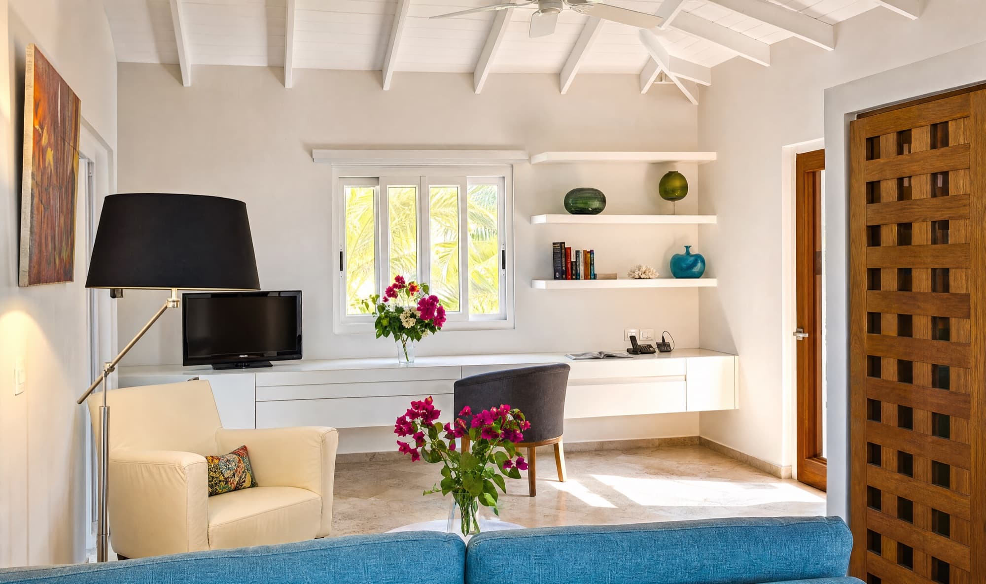 Cream armchair, media corner and floating white shelves in the living room