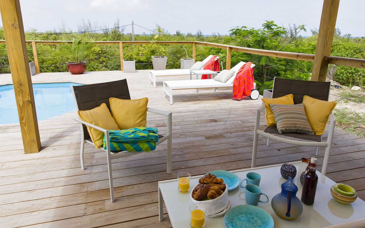 Wide sun deck with armchairs overlooking lush Terres Basses greenery