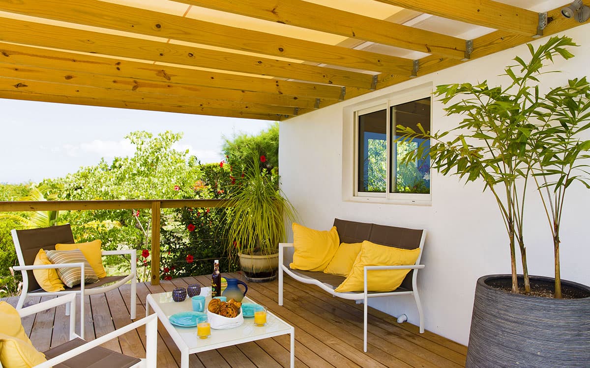 Gazebo shade structure with yellow cushions on the deck