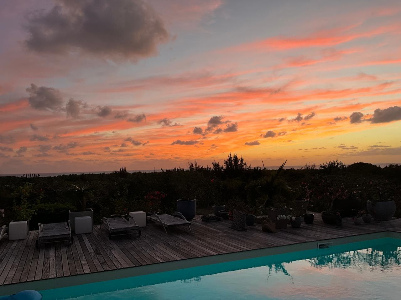 Pastel pink and orange sunset reflected in the estate pool