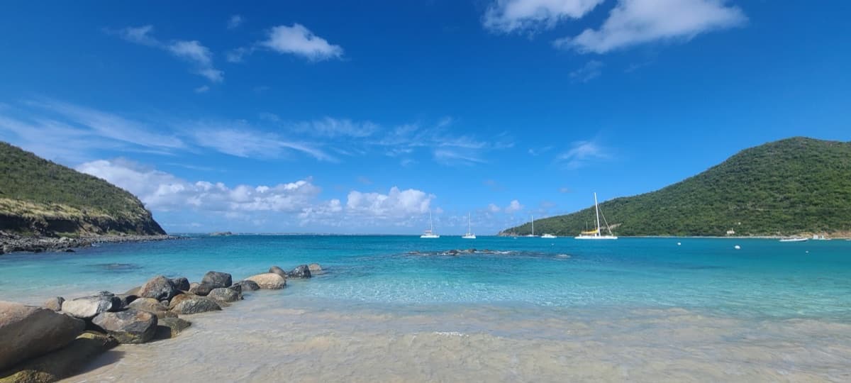 La crique abritée de l’Anse Marcel, avec une eau calme et des mornes verts