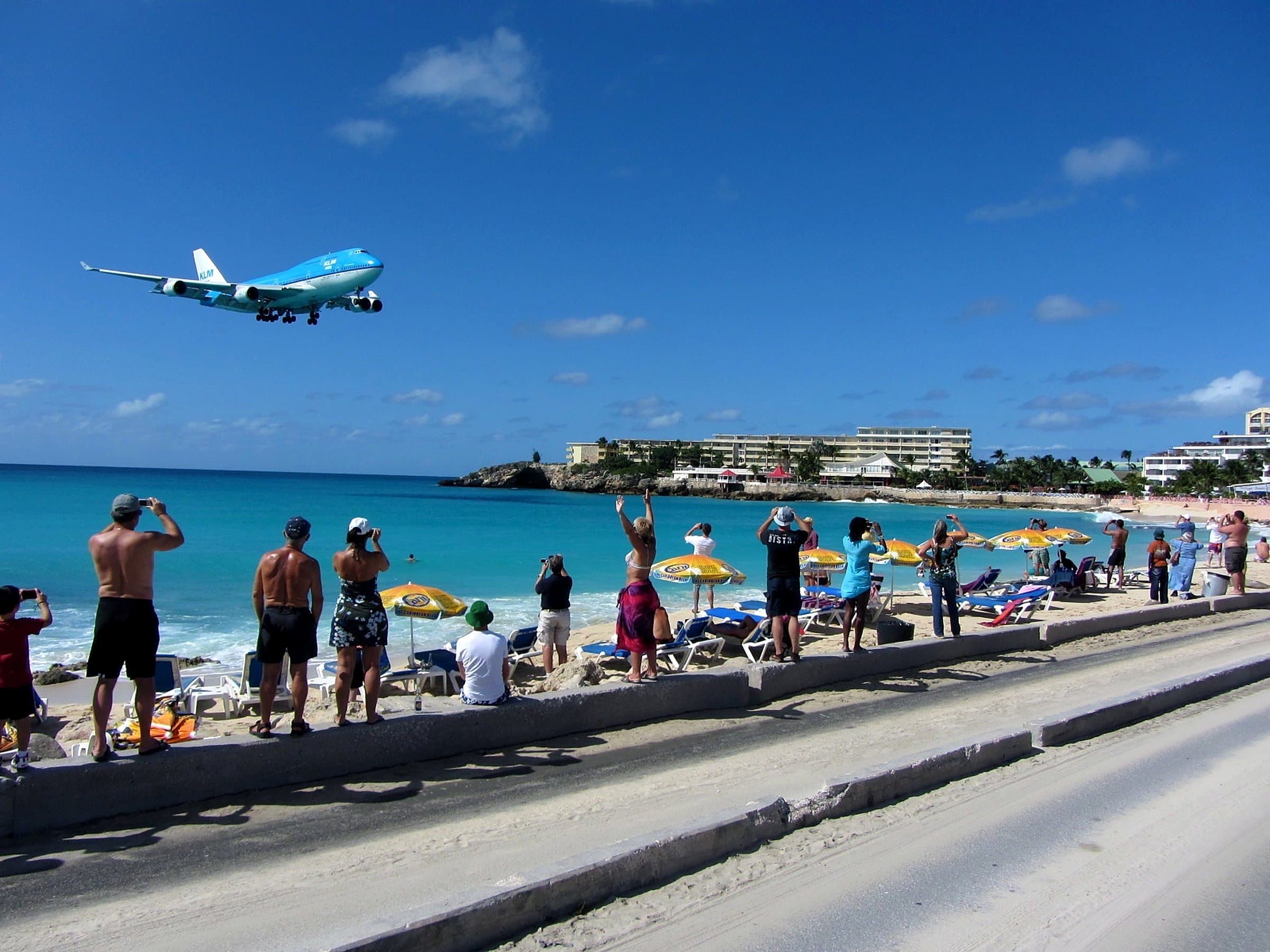 Un avion de KLM en approche à basse altitude au-dessus de Maho Beach, sous le regard des baigneurs