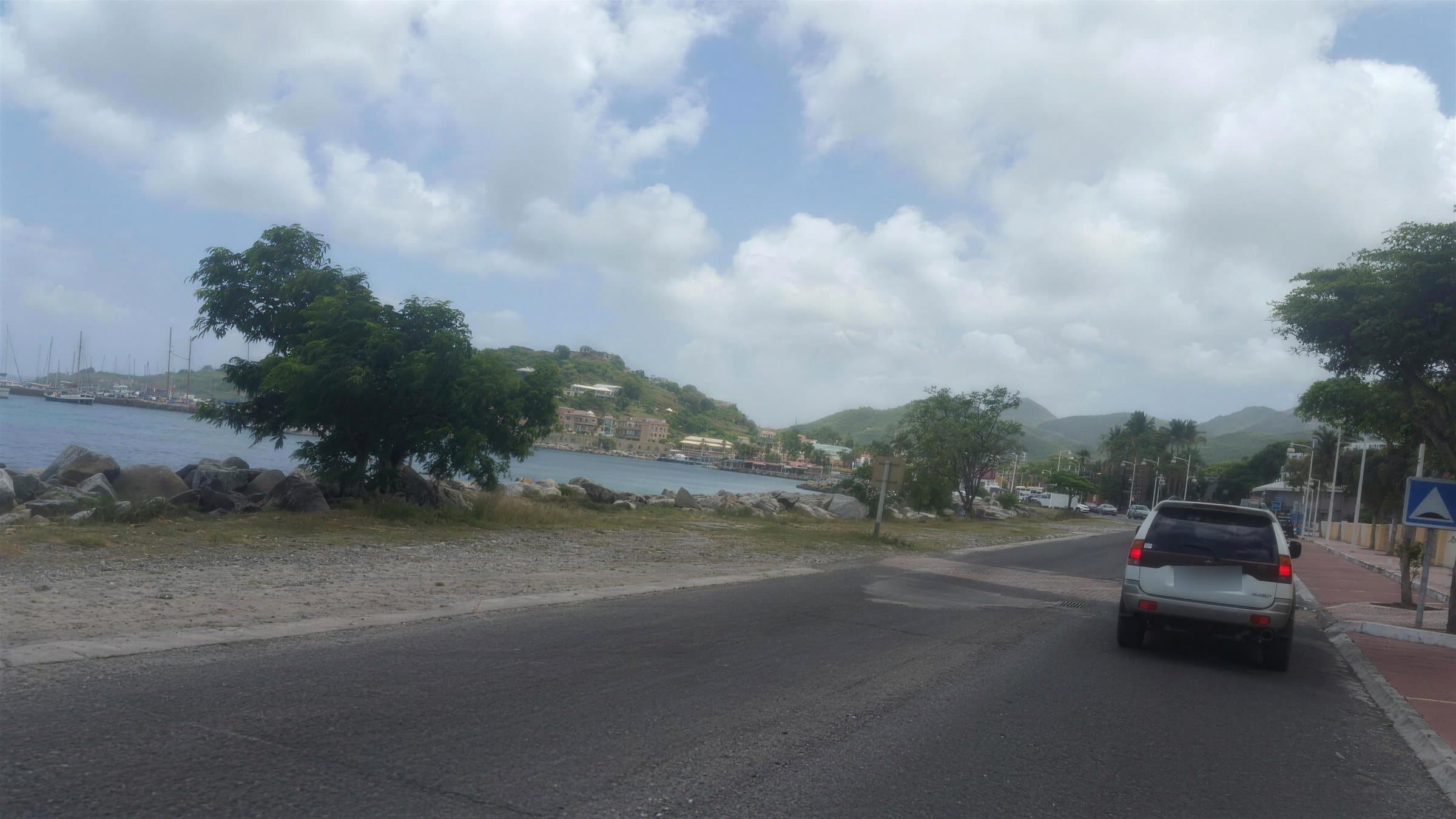 The road into Marigot along the bay, with Fort Louis on the hill and boats in the marina
