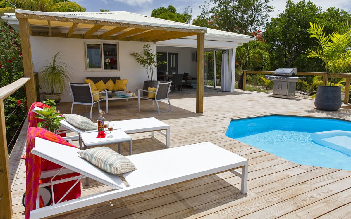 Pool, gazebo and outdoor living at Villa Zenitude with doors open to the deck